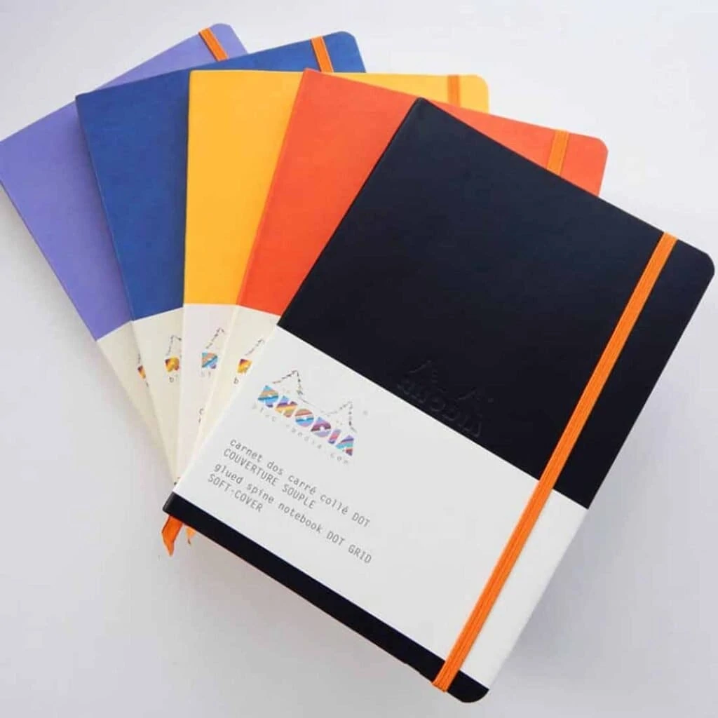 stack of 5 Rhodiarama Soft Cover Notebooks in black, orange, yellow, blue and purple